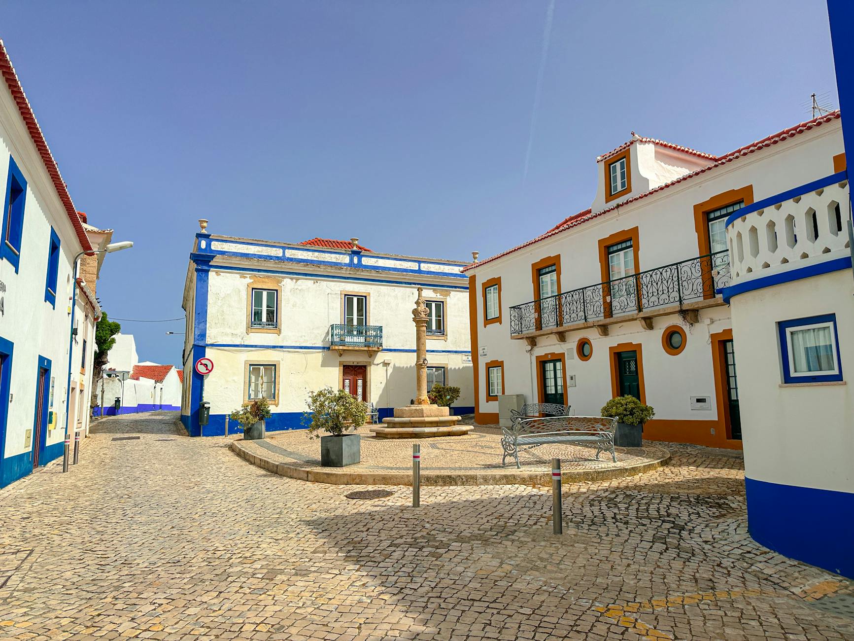 Letni rynek małego miasteczka z białą zabudową i brukiem