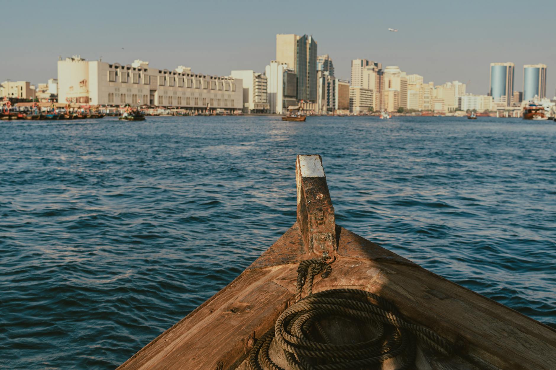 Łódź na wodzie z widokiem na nowoczesną panoramę Dubaju i stare dzielnice