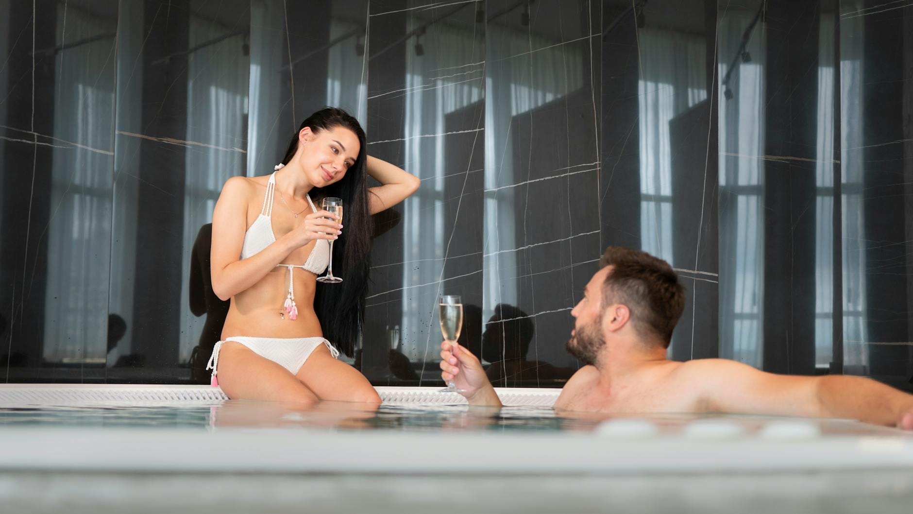 Para w jacuzzi z lampką szampana podczas weekendu w Lublinie
