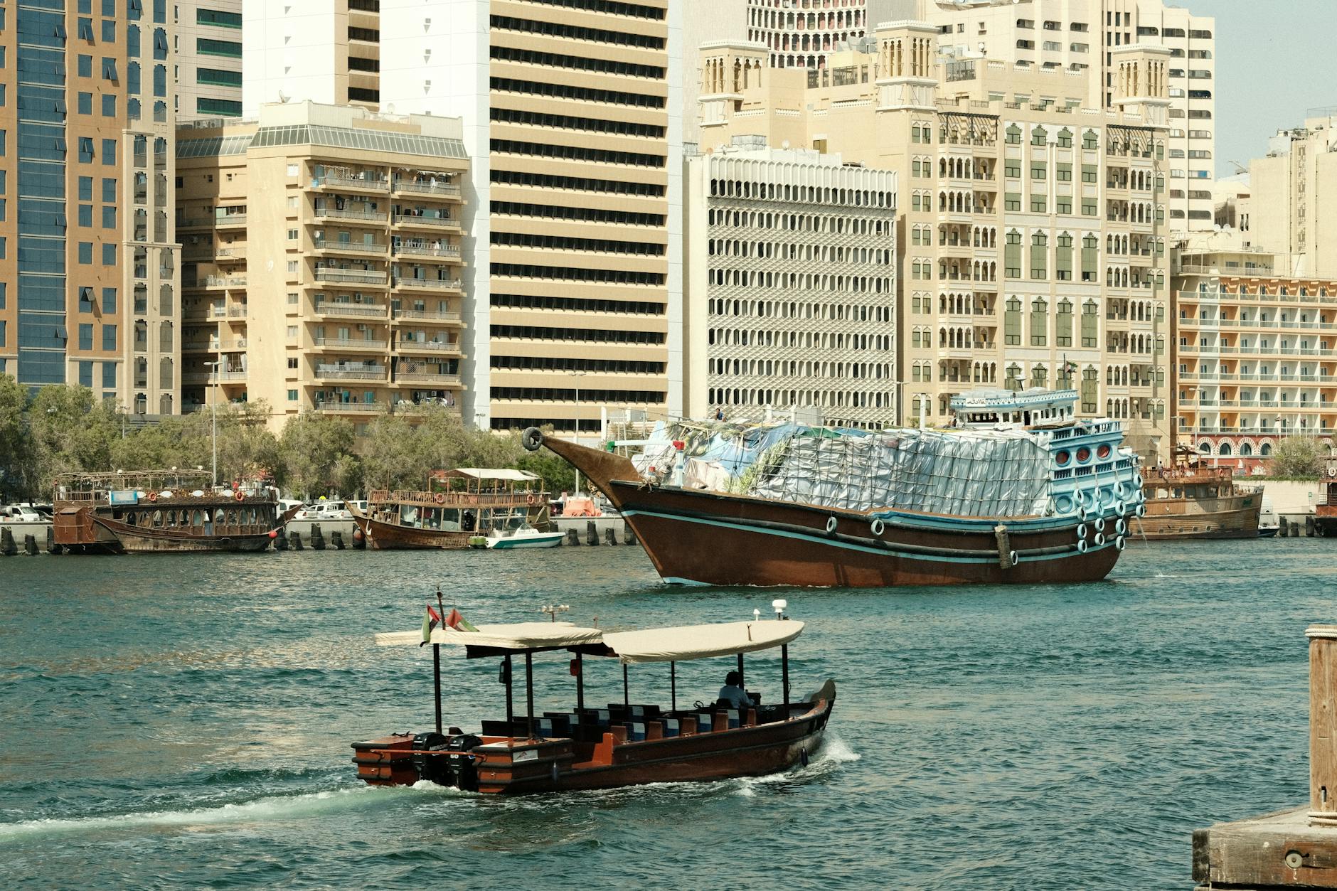 Tradycyjne drewniane łodzie na Dubai Creek na tle nowoczesnej zabudowy