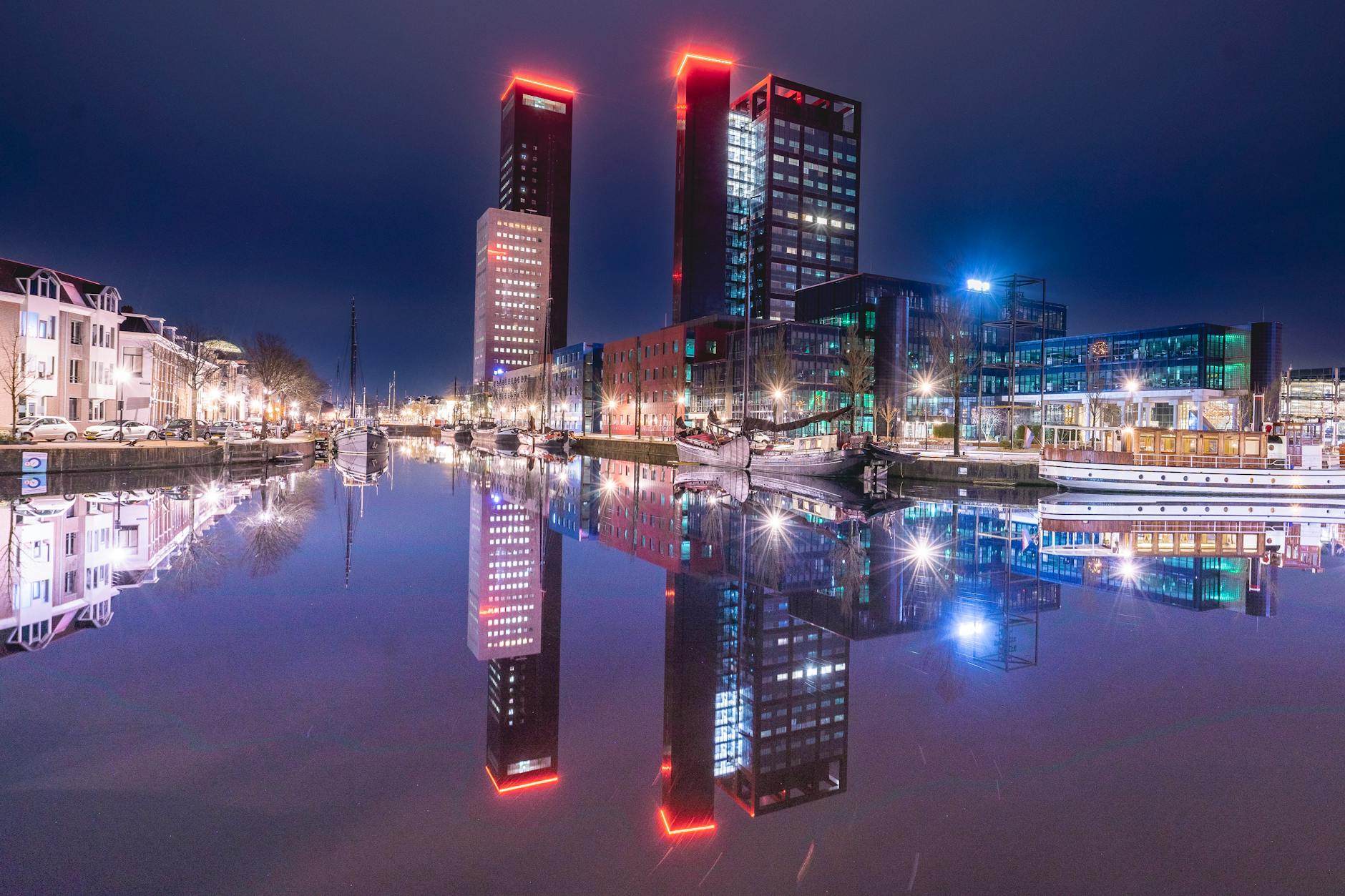 Nocna panorama nowoczesnych wieżowców odbijających się w wodzie