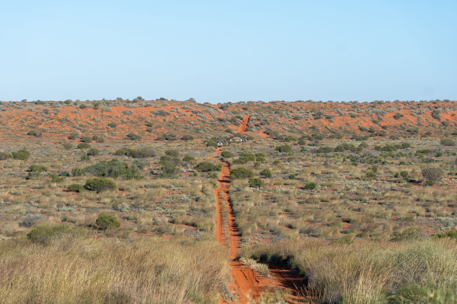 Pusta droga przez pustynny outback Australii wśród czerwonego piasku