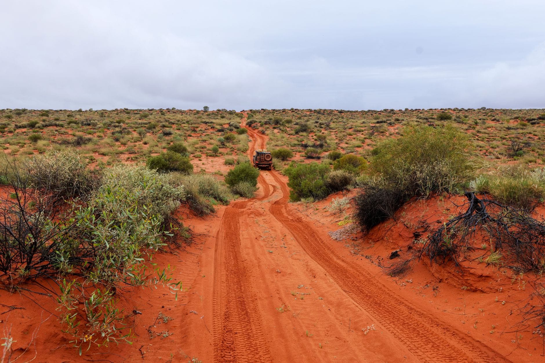 Samochód terenowy na czerwonej drodze w australijskim outbacku